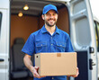 © Radorog. - a courier in blue clothes holds a box in his hands near a white van, the concept of parcel delivery