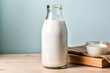 © Diana - A clear glass bottle of fresh milk placed on a light wooden table with a clean, minimalist blue background. A perfect representation of dairy products, breakfast, or healthy living concepts.