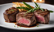 © Miklos - Three juicy, medium-rare steaks are served with rosemary and fries on a white plate