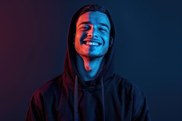 A person wearing a black hoodie and smiling directly into the camera