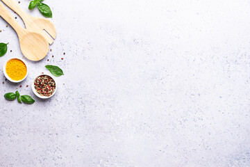 Wooden cutlety set, basil leaves and spices on gray concrete background with copy space for your design. Food blog banner, recipe book cover mock up.