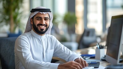 Aufkleber - Smiling young middle eastern businessman sitting at worktable at modern office typing on computer keyboard sending emails to his business partners working on marketing research copy sp : Generative AI