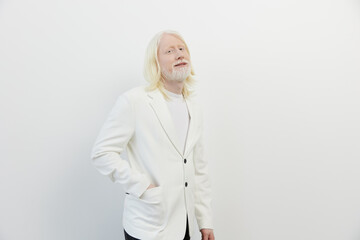 Stylish man with long blonde hair in a white blazer on a plain white background, exuding confidence and sophistication with a casual pose, perfect for fashion or portrait themes