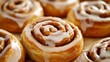 © fotogurme - Freshly baked cinnamon rolls dripping with glaze soft dough with golden edges cozy autumn treat, super macro shot