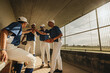 © Jacob Lund - Amateur baseball league players in team huddle in the dugout