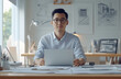 © Ailish_ART - A professional photo of a man sitting at his desk in front of a laptop, wearing a shirt.