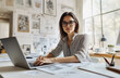 © Ailish_ART - A professional photo of a female sitting at her desk in front of a laptop, wearing a shirt.
