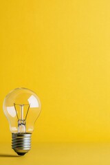 A vintage light bulb placed against a vibrant yellow background for aesthetic appeal