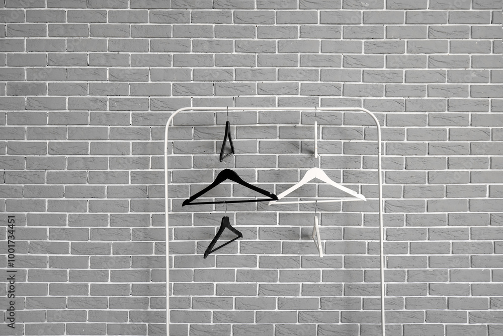 Rack with wooden clothes hangers on grey brick wall background