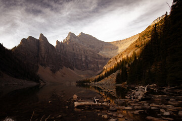 view of a calm lake in high altitude with mountain peaks in the background under the golden light of a sunset in fall