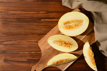 Board with pieces of sweet melon on wooden table