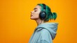 © MUdaylah - Close up side view young fun happy woman with dyed green hair wearing hoody casual clothes listen to music in headphones isolated on plain yellow orange background studio portrait. with generative ai
