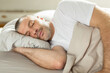 © Home-stock - Asleep European middle aged man resting peacefully in comfortable bed, lying with closed eyes under blanket. Time to rest and nap concept