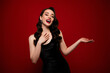 © Beauty Hero - Photo of gorgeous attractive fashion model wearing black dress hold empty space isolated on red color background