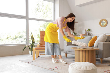 Canvas Print - Young woman cleaning table with pp-duster at home