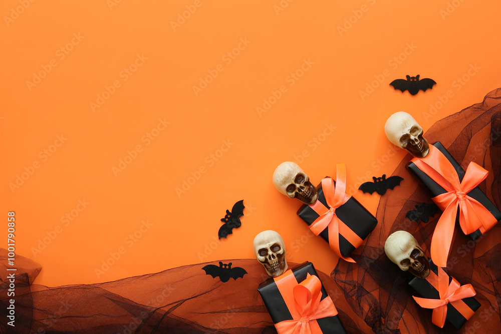 Halloween gifts, skulls, bats and tulle on orange background. Top view