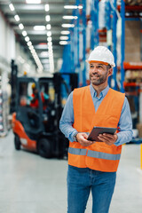 Warehouse manager with tablet, monitoring operations closely