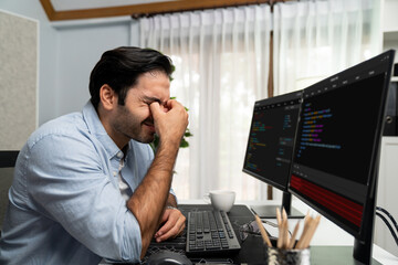 Stressful IT developer having eyestrain to overwork in data software development on two pc screen, creating application program update version online website page system at modern office. Surmise.