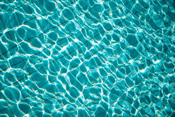 swimming pool with rippled water in sunny day in the summer