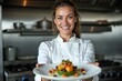 © Derek Brumby - A smiling chef presents an artfully plated dish in a professional kitchen, showcasing culinary skill and creativity, emphasizing the artistry involved in fine dining.