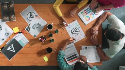 Top view of manager writing idea on sticky notes and explain idea about web design. Professional marketing team or programmer brainstorming idea while looking at tablet with color palette. Symposium.