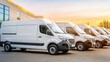 © Iswanto - Row of white delivery vans parked in front of a warehouse at sunset.