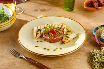 Wall Mural - Gourmet Beef Tartare with Grilled Bread on Rustic Wooden Table