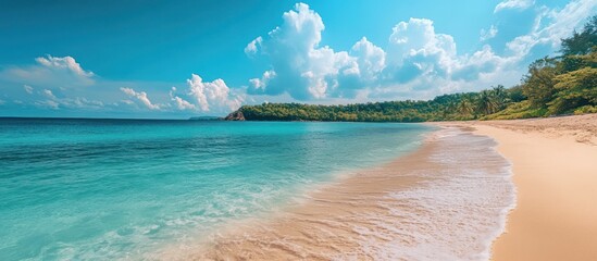 A pristine white sand beach with turquoise water and a lush green hillside.