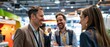 © Surachetsh - Male and female attendees engage in conversation at a booth during a commercial photography networking trade fair, trade show, and seminar event.