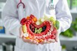 © stock.finder - Doctor holding a model of the human digestive system made of fruits and vegetables. Health and nutrition concept.