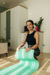 © Roman - A woman unwinding a yoga mat in her bedroom