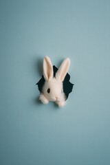 A cute rabbit peeking through a torn blue wall, showcasing a playful and imaginative scene