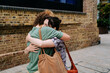 © Westend61 - Happy lesbian couple hugging each other near building