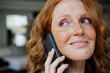 © Westend61 - Woman with freckles talking on smart phone
