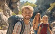 © Matthew - A group of young hikers smiling while exploring a rocky outdoor trail, enjoying nature together.