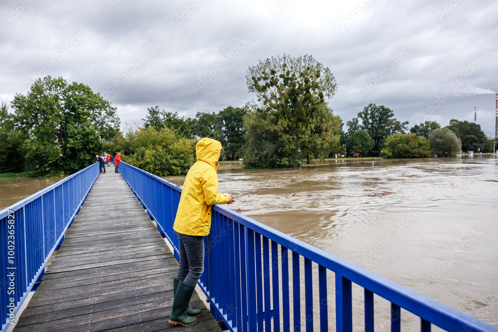 Worried people looking from bridge at flooded river. Extreme weather ...