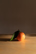 © Joske - Small tangerine with green leaf on a table with striking autumn light.