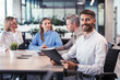 © ty - Businessman with colleagues in the background in office.