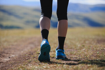 Poster - Fitness woman runner running at high altitude grassland mountain top road