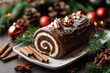 © Alexandra - Chocolate yule log cake sitting on a white plate and decorated with christmas ornaments