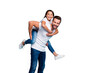 © deagreez - Portrait of cheerful people laughing piggyback wearing white t-shirt denim jeans isolated over blue background
