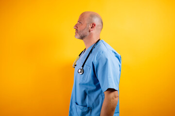 Profile view of a serious looking doctor or nurse wearing a blue surgical gown.