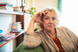 © Marko Geber - Portrait of a confident middle aged woman sitting on couch looking directly at camera