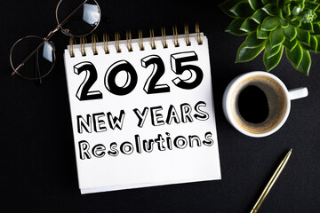 Wall Mural - 2025 New year resolutions on desk. 2025 goals list with notebook, coffee cup, plant on black table. Resolutions, plan, goals, action, idea concept. New Year 2025 resolutions. Copy space