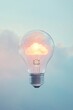 © grey - A glowing lightbulb with a cloud icon inside, set against a soft, pale blue sky, symbolizing cloud computing and data flow.