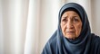 © Arceli - Concerned Middle Eastern elderly woman with a worried expression on a soft white backdrop