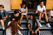 © Maskot - High angle view of male and female junior high students spending leisure time while sitting on steps in front of school