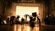 © savittree - Silhouetted crew adjusting lighting rigs and cameras in a massive film production studio filled with professional-grade equipment.