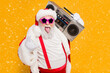 © deagreez - Portrait of fat white hair funny santa claus heavy metal x-mas hipster party hard on noel celebration show horns sign hold retro boombox wear trendy hat suspenders isolated yellow color background