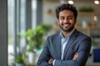 © Visual Odyssey - Happy indian business man in suit in modern office, Generative AI
